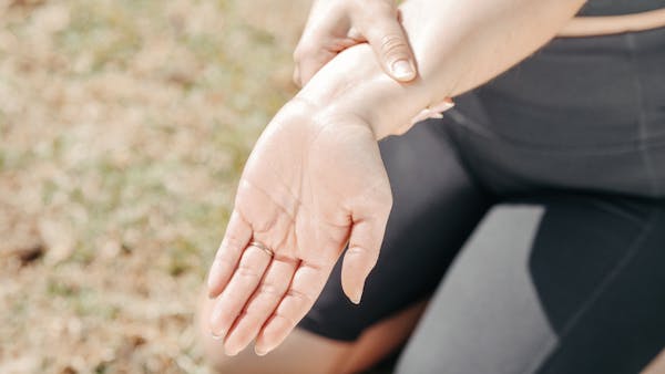 Person holding wrist in pain indicating TFCC injury