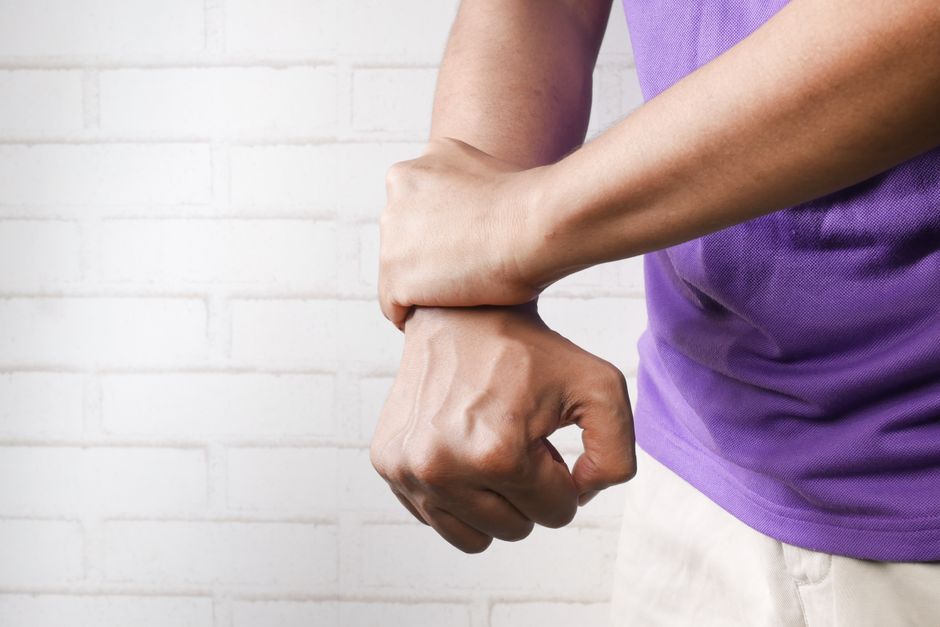 Person holding their wrist in pain, illustrating carpal tunnel syndrome symptoms