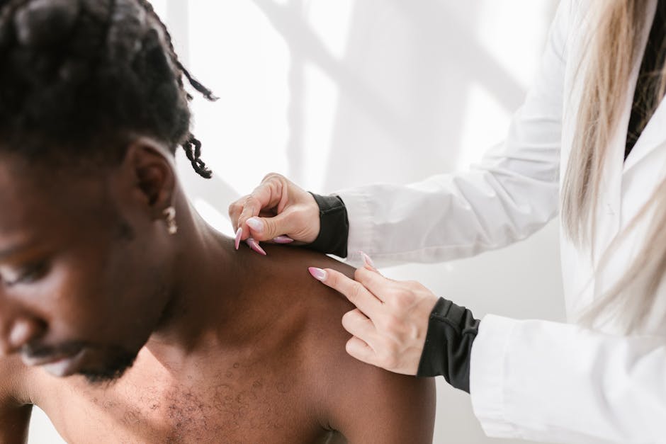 Healthcare professional examining a man's shoulder injury, relevant to rotator cuff repair in Treasure Valley.